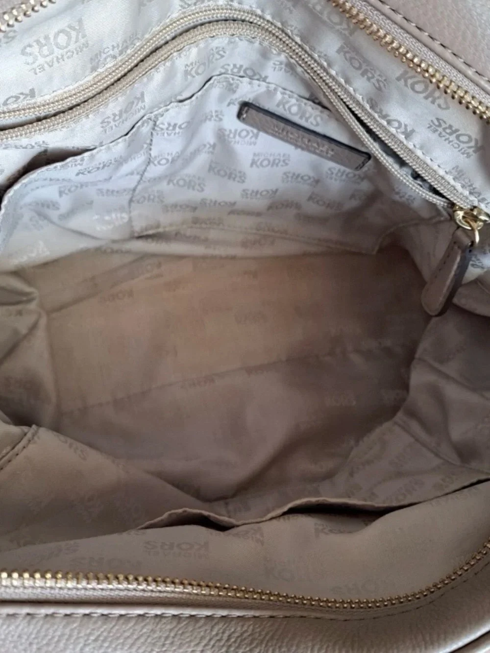 Michael Kors Knox Satchel featuring a prominent tassel and gold-tone hardware